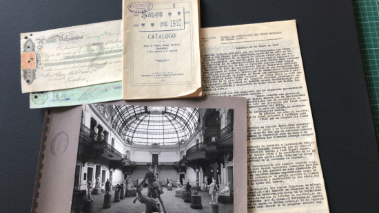 Documentos antiguos y una fotografía en blanco y negro sobre un fondo negro